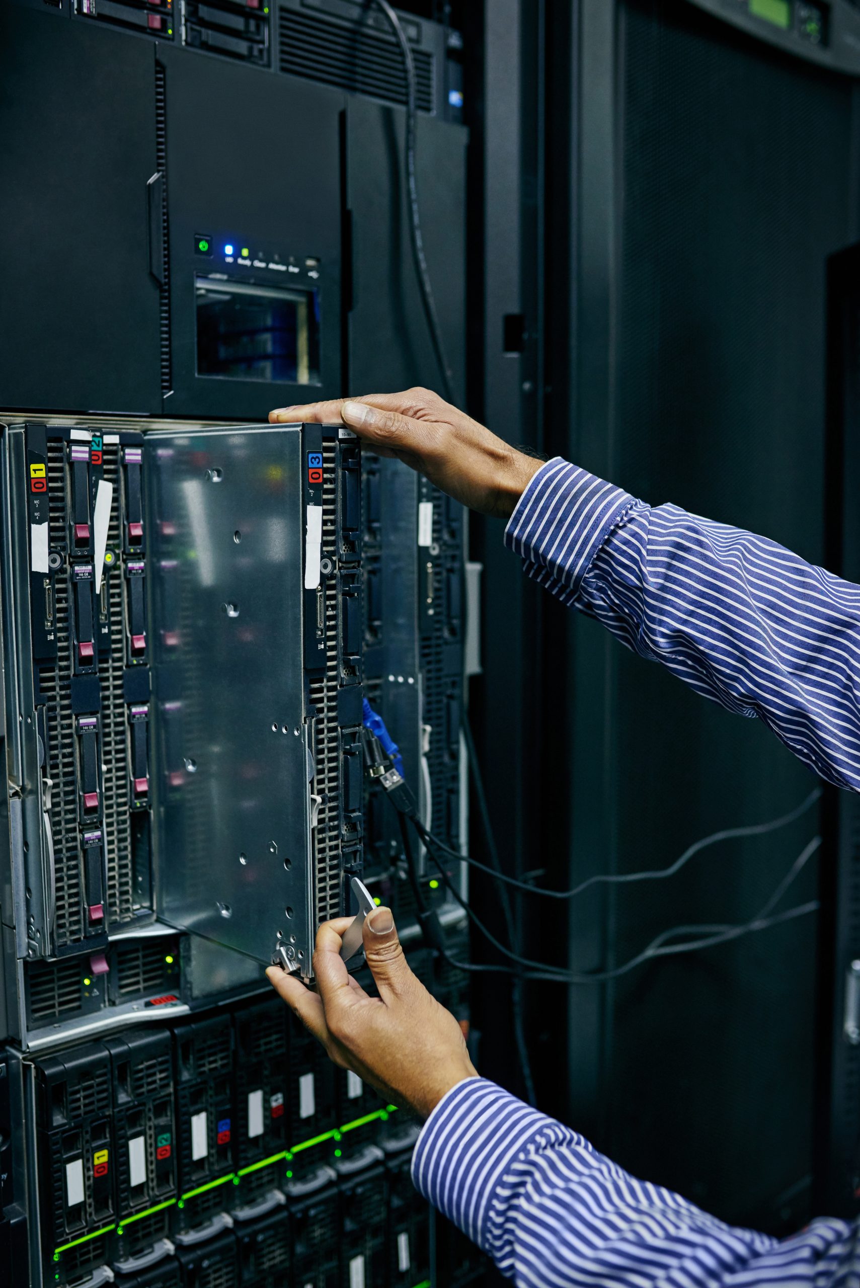 Technician servicing hardware inside an open server chassis.