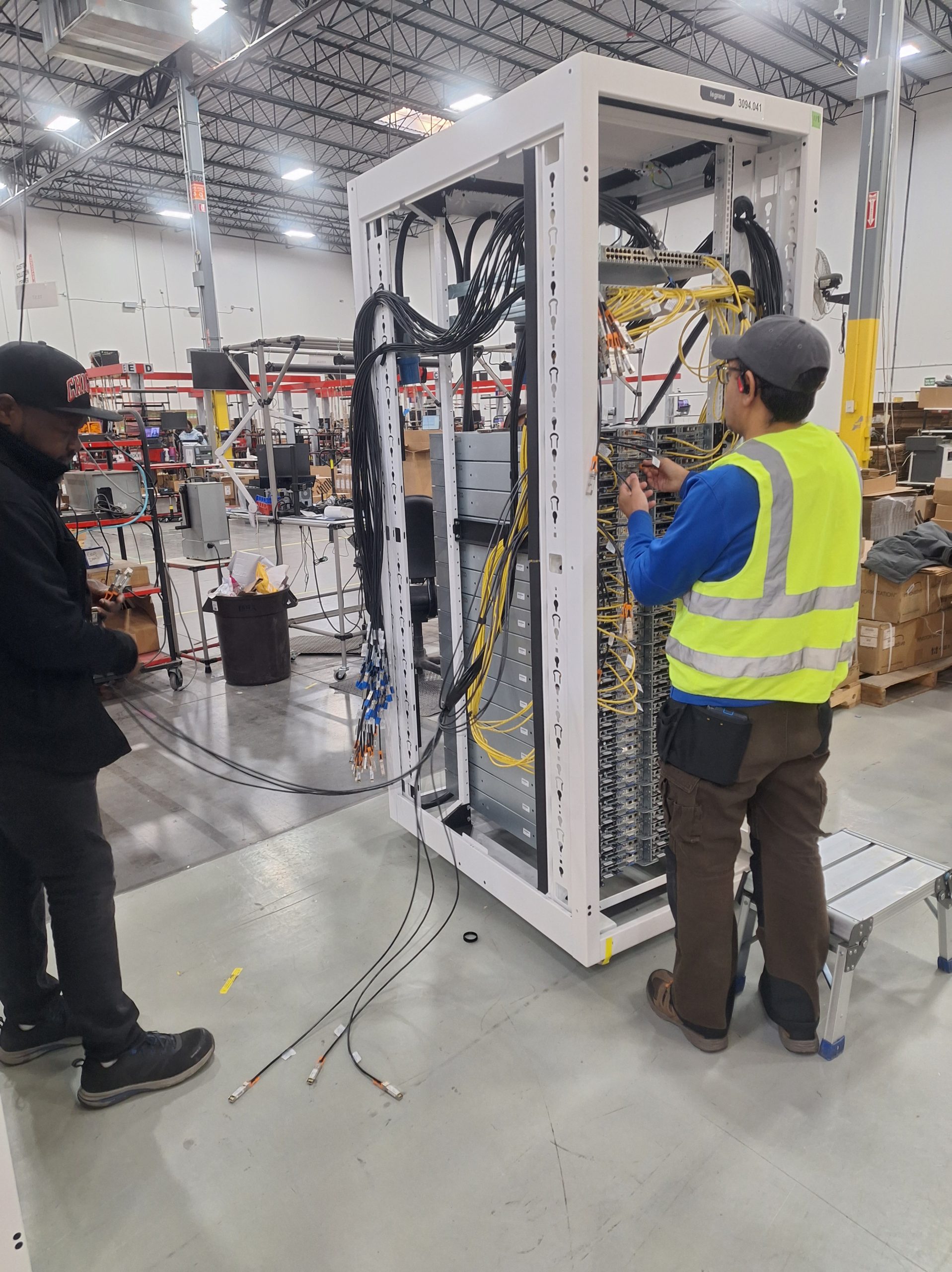 Jeda technicians coordinating network installation inside a large facility.