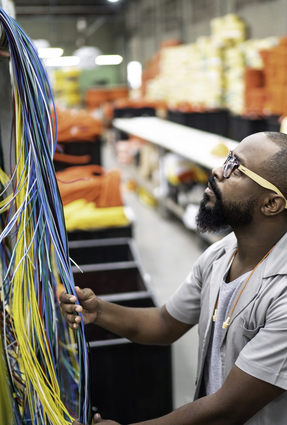 Field technician managing patch cables inside a network rack.