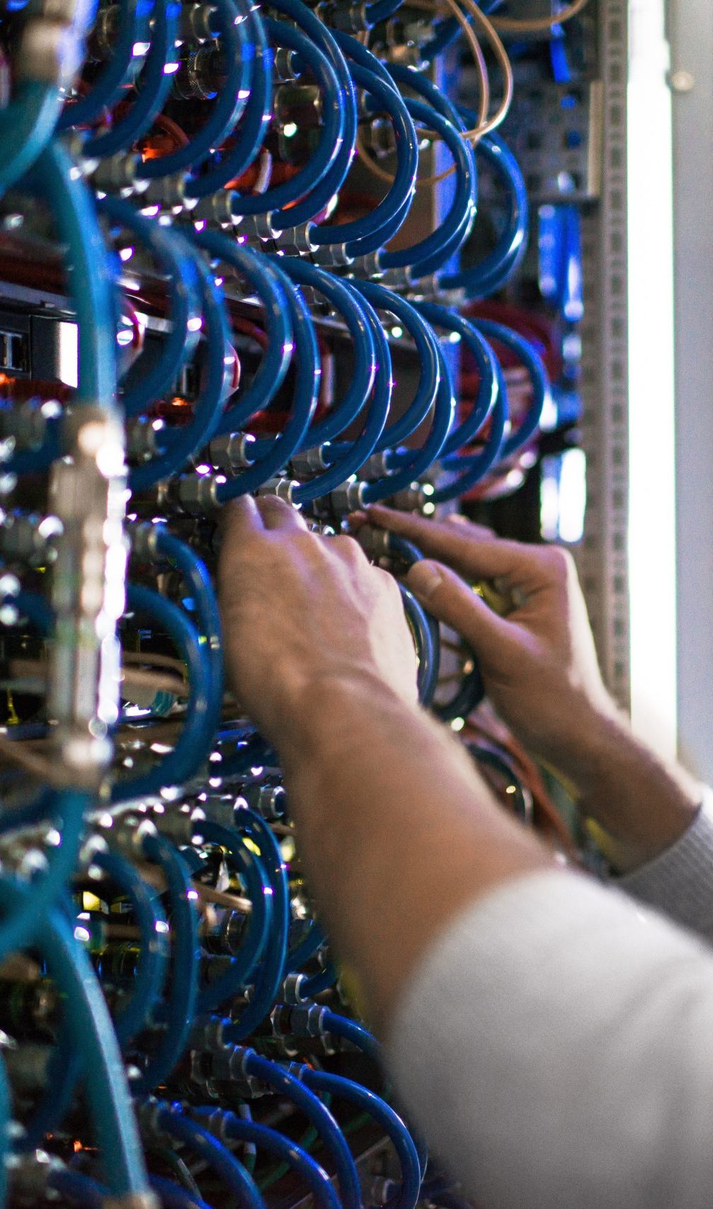 Close-up of fiber cables being installed inside a network rack.